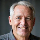 Retrato de um homem sorridente de 50 anos com expressão calma e saudável.